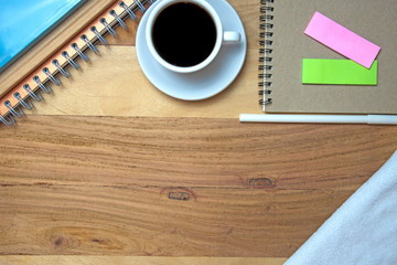 Wooden work desk with a coffee mug, notebook, pen, Top view with copy space.