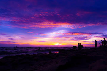 the twilight sky over the sea and silhououng people on the beachette of y for baclground, colorful of the sky in the summer
