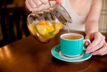 Female hands holding tea pot  hot green tea cup beverage, drinks citrus . Horizontal several objects copyspace