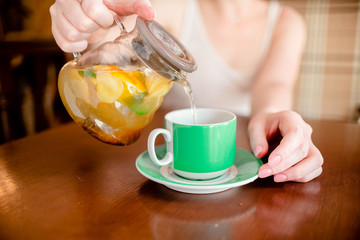Female hands hold hot green  coffee cup beverage, drinks cappuccino. Horizontal several objects copyspace