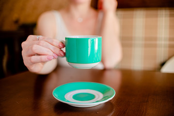 Female hands hold hot green  coffee cup beverage, drinks cappuccino. Horizontal several objects copyspace