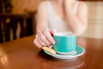 Female hands hold hot green  coffee cup beverage, drinks cappuccino. Horizontal several objects copyspace