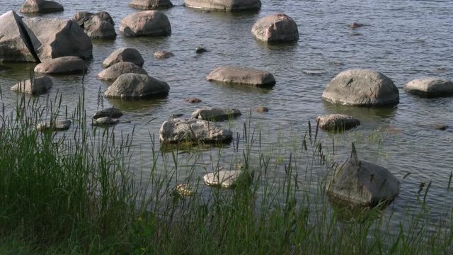 Stones in the water. Light breeze. Baltic Sea, Gulf of Finland, coast of K&auml;smu. Tilt up.