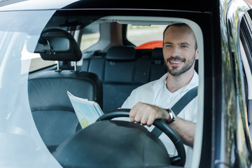 Obraz premium selective focus of happy man driving car and holding map