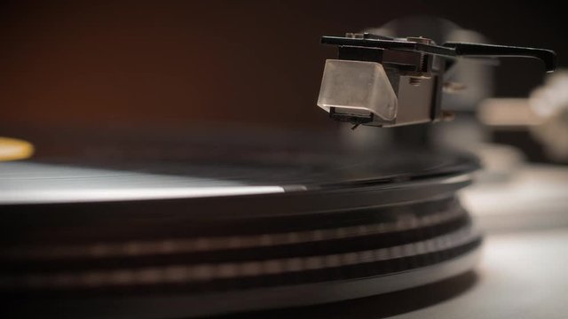 Dropping Stylus Needle On Vinyl Record Playing With Disc Rotating Close Up. Old dusty turntable.
