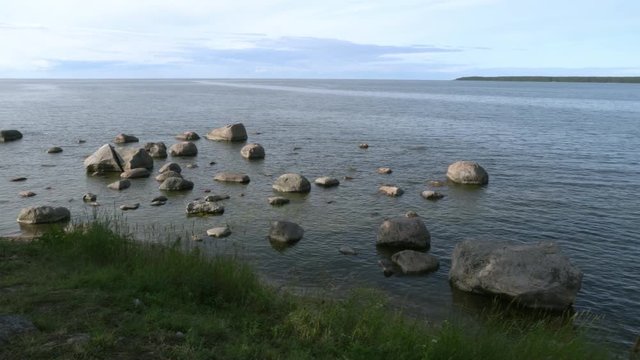 Stones in the water.  Baltic Sea, Gulf of Finland, coast of K&auml;smu. Cape at background. Panorama to right.