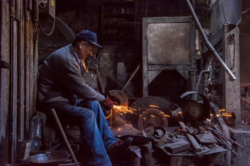Obraz na płótnie Canvas the blacksmith polishing metal products