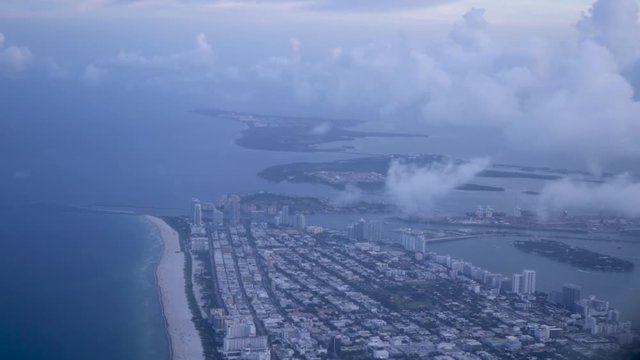 Shot out of a plane while evening of the city and beach of Miami, Florida.