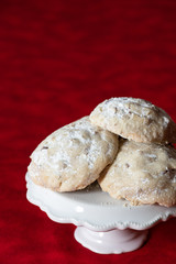 Stack of Russian Tea Cake cookies on a white cake plate on a multi-shade red background 