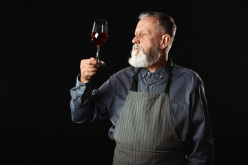 Portrait of mature sommelier on dark background