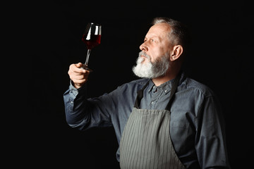 Portrait of mature sommelier on dark background