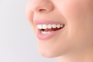 Woman with healthy teeth on light background, closeup