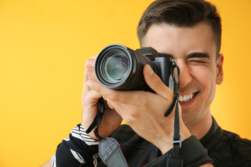 Fototapeta premium Male photographer on color background