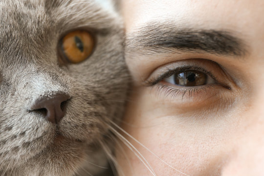 Young man with cute funny cat, closeup