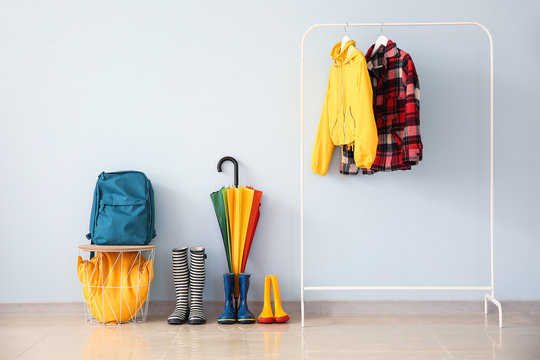 Stylish umbrella with gumboots in hall
