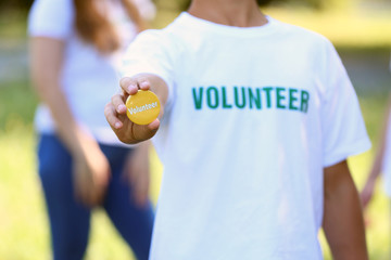Young volunteer with badge outdoors