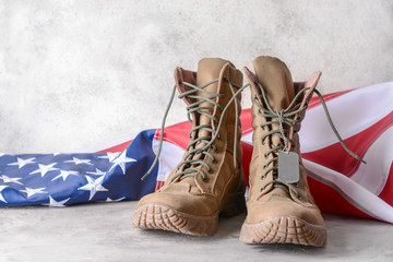 Military boots and USA flag on table