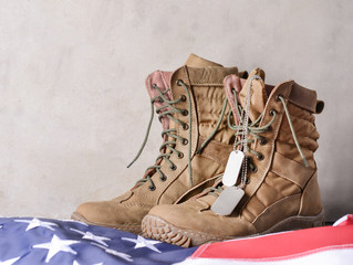 Military boots and USA flag on grey background