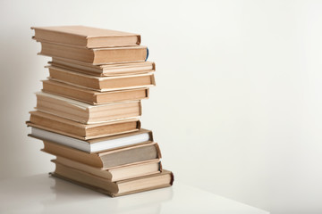 Stack of books on table against light background