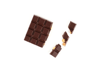 bar of dark chocolate with hazelnuts. Pieces of chocolate with nuts, isolated on white background.