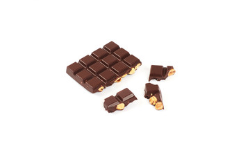 bar of dark chocolate with hazelnuts. Pieces of chocolate with nuts, isolated on white background.