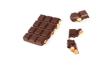 bar of dark chocolate with hazelnuts. Pieces of chocolate with nuts, isolated on white background.