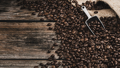 close up coffee beans with coffee spoon on brown wooden background