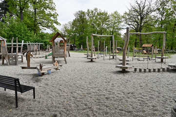 Children's wooden jungle gym and playground on gravel sand.