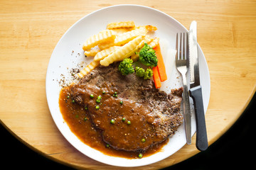 Ribeye steak on wooden table.