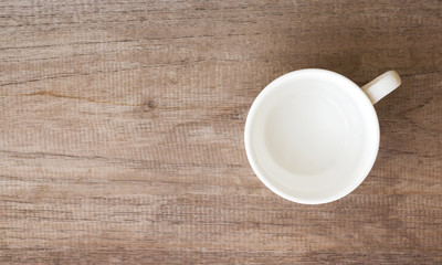 Empty clean cup on wood table. Top view with copy space.