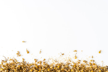 Dried camomile flowers on white table with copyspace