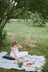Little girl in the garden with a picnic