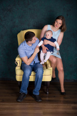 Caucasian Family Posing on Big Armchair in Studio