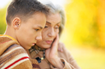 Fototapeta premium Portrait of grandmother and grandson hugging in park