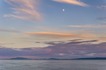 cloudy sunset and moon in strait of Georgia between Vancouver and Victoria.