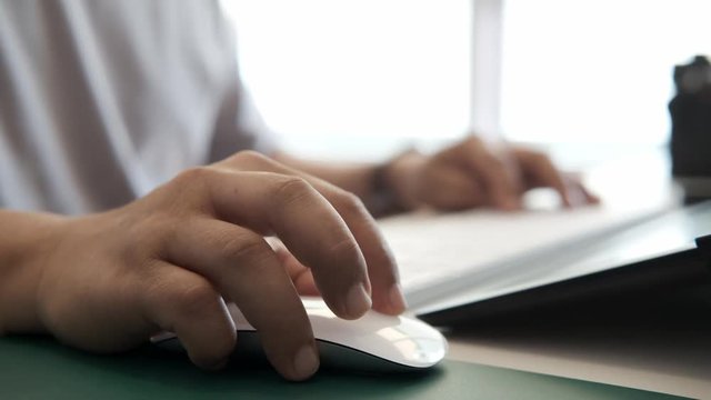 Close up man's hand using a wireless computer mouse.