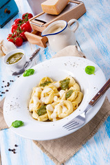 Tortellini di formaggio with basil pesto and cheese sauce