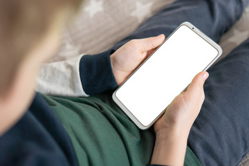 Smartphone with a white screen in hand child . close up top view Phone a for mock up is holding...