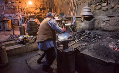 traditional blacksmith manually forging the molten metal