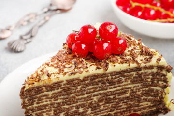 Cake of thin chocolate pancakes and pistachio cream with red currant berries.