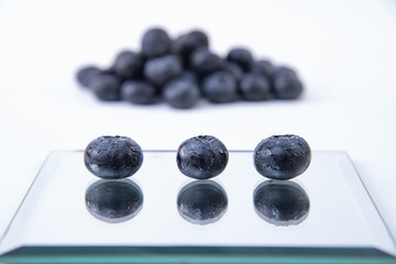 Sweet blueberries - Pile of freshly harvested blueberries on a white background - Large, sweet wet blueberries on a glass plate