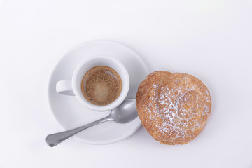 Top view golden puff pastry roll with powdered sugar on top and a cup of coffee