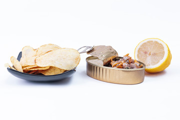 Canned cockles accompanied by french fries served on a plate and a fresh lemon