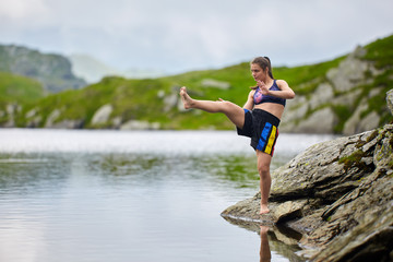 Woman kickbox fighter training by the lake