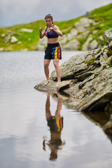 Woman kickbox fighter training by the lake