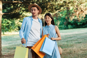 Naklejka premium happy young couple with shopping bags