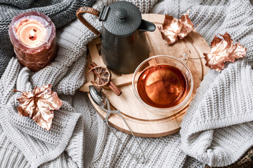 Cozy autumn morning breakfast in bed still life scene. Steaming cup of hot coffee, tea standing near window. Fall.