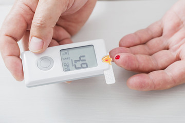 man measures sugar level with a glucometer