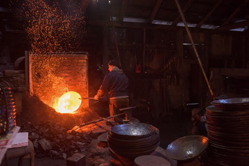 blacksmith workers using mechanical hammer at workshop