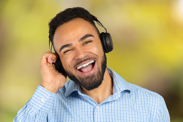 Happy african man smiling listening to music in headphones. White background